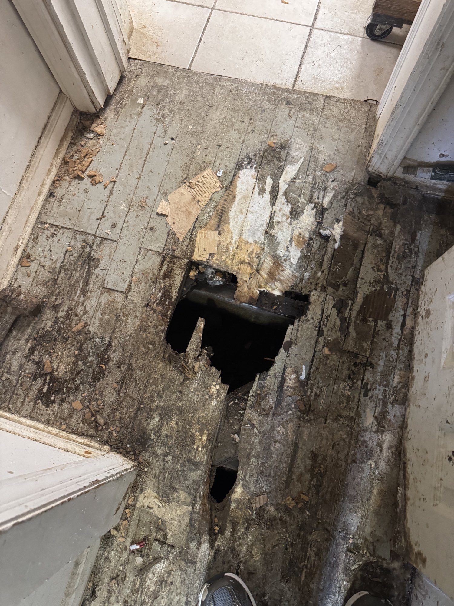 Rotted, water-damaged wood floor with a hole through the decking before structural repair in Morris County, New Jersey
