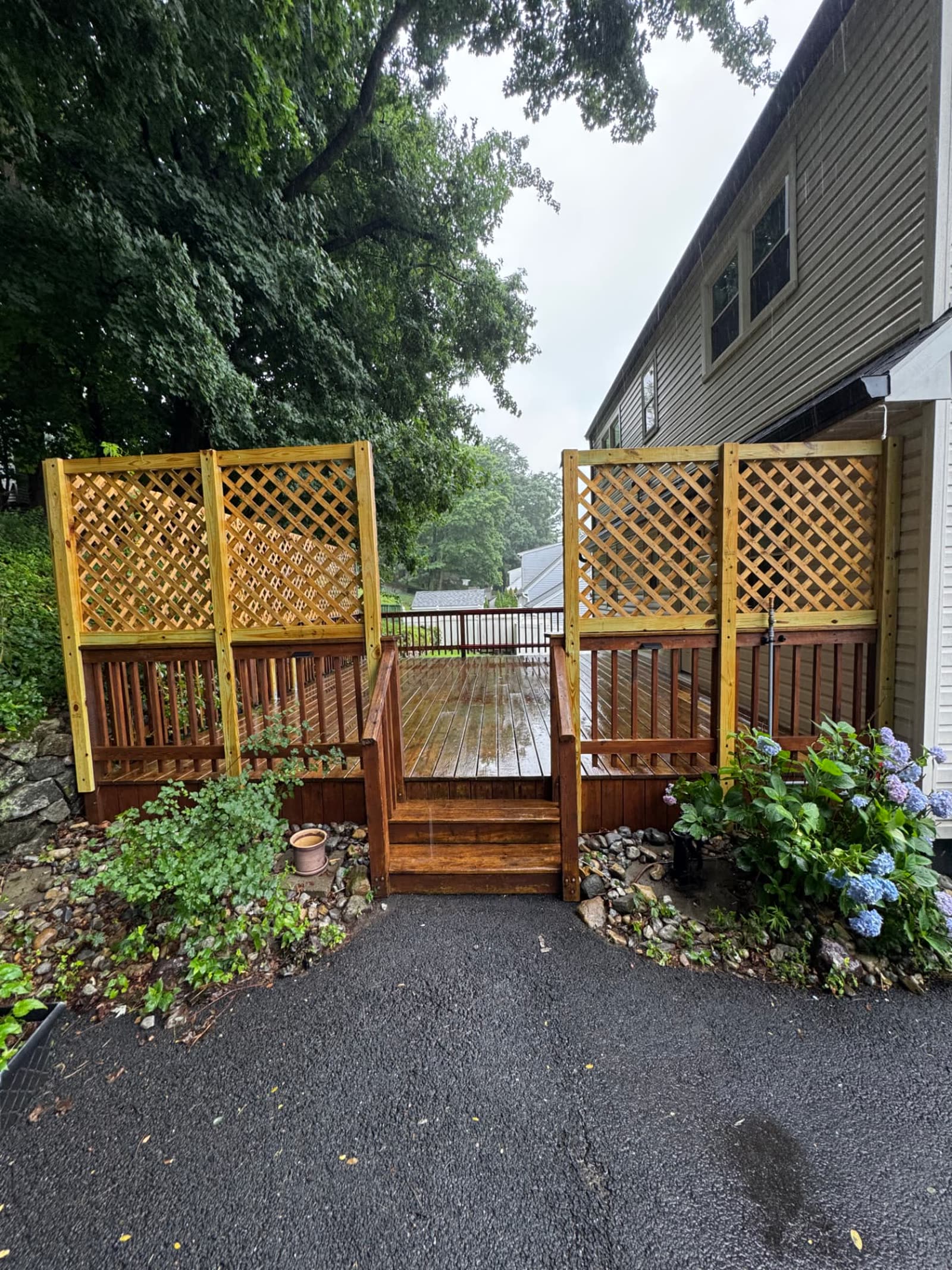 Deck before exterior painting with weathered stained wood railings and bare pressure-treated lattice