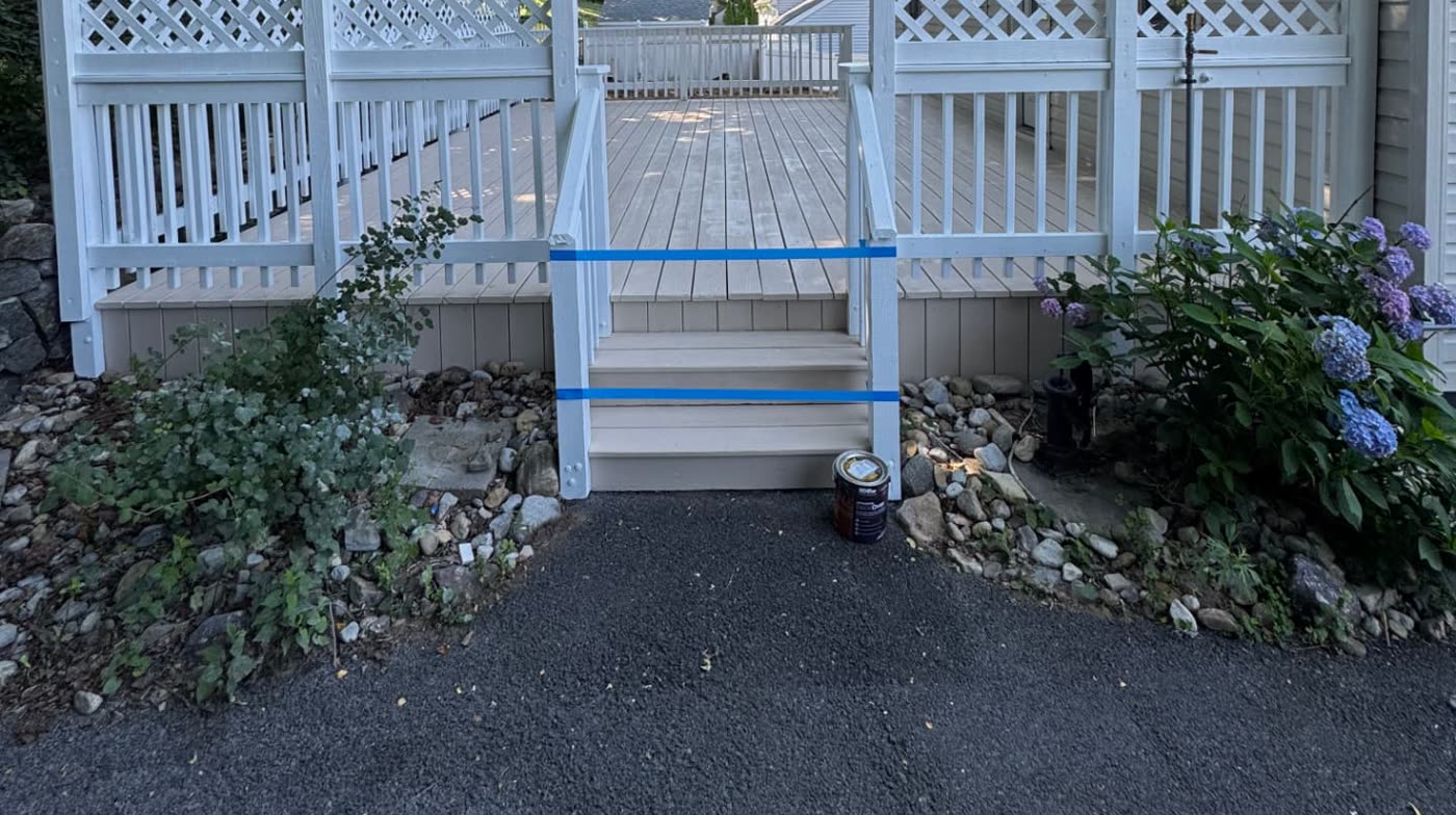 Close view of the freshly painted deck steps, railing, and skirting with a clean, durable white finish
