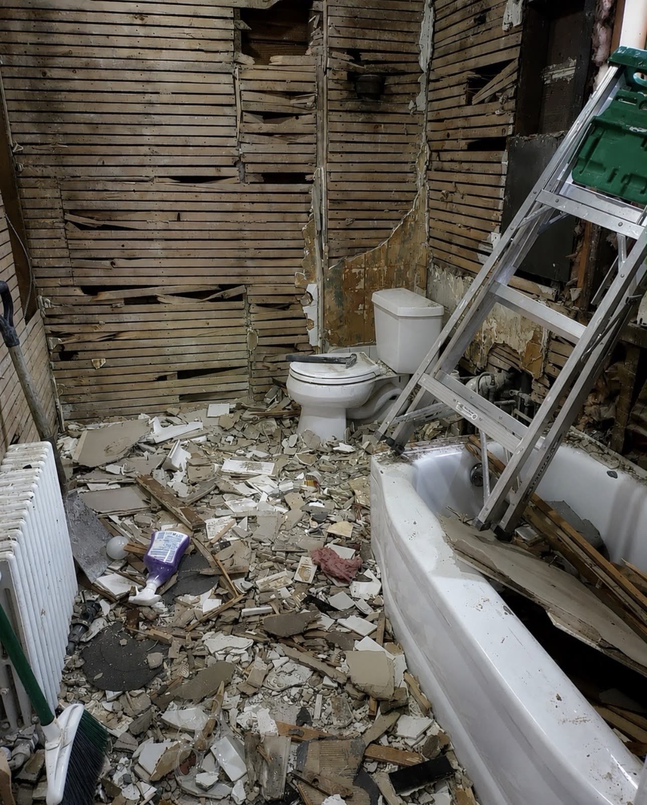 Bathroom during demolition with tile and plaster removed down to the lath